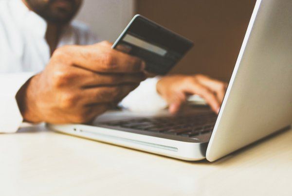 man met creditcard achter laptop
